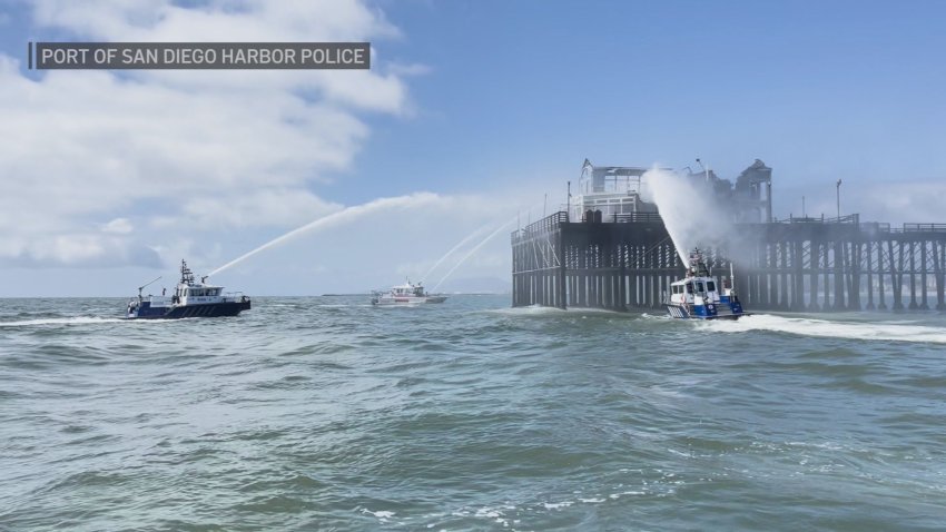 Boats spray water on a pier.