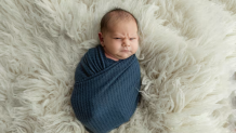 A baby making a face at the camera.