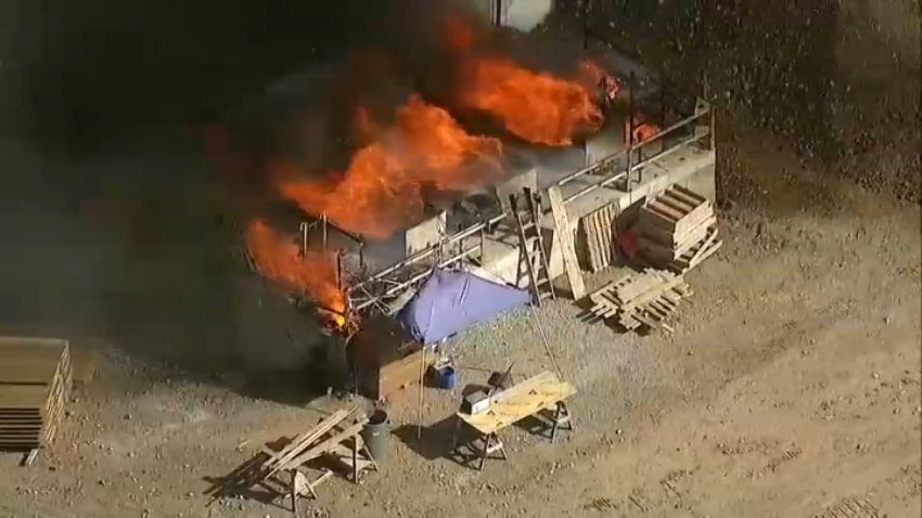 A fire burns at the Padres Dam Municipal Water Reclamation Plant in Santee, sending thick, black smoke into the air, May 22, 2024.