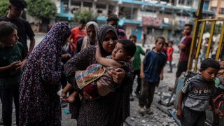 A Palestinian woman holding a boy.