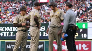 ANAHEIM, CALIFORNIA – JUNE 05: Manny Machado #13 of the San Diego Padres speaks with Mike Shildt #8 and medical staff after an injury running to first base during the fourth inning against the Los Angeles Angels at Angel Stadium of Anaheim on June 05, 2024 in Anaheim, California. (Photo by Harry How/Getty Images)