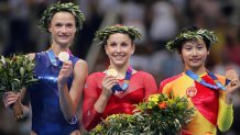 ATHENS, Greece:  Gold medal winner Carly Patterson (C) of the US, bronze winner Zhang Nan of China (R) and silver winner Svetlana Khorkina (L) of Russia hold up their medals from the podium at the end of the Women's Individual All-Around Gymnastics Final in the Olympic Indoor Hall at the Olympic Games in Athens, 19 August 2004. Patterson became only the second American to win Olympic all-around gold, the first being Mary Lou Retton at the boycott-diminished 1984 Olympics.    AFP PHOTO/KAZUHIRO NOGI  (Photo credit should read KAZUHIRO NOGI/AFP via Getty Images)