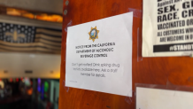 A sign on the door of the Silver Fox in Pacific Beach that reads, "Don’t get roofied! Drink spiking drug test kits available here. Ask a staff member for details."