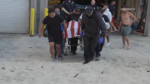 Loved ones carry the body of a Oakland firefighter who dronwned in San Diego's Pacific Beach on June 27.