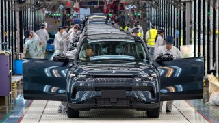 Employees work on the assembly line of C11 electric SUV at a factory of Chinese EV startup Leapmotor on April 26, 2023 in Jinhua, Zhejiang Province of China.