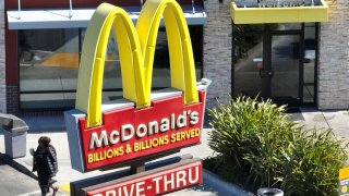 In an aerial view, a customer walks by a sign as they leave a McDonald’s restaurant in San Pablo, California, on April 3, 2023.