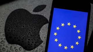 The European Union flag displayed on a mobile phone screen in front of the Apple logo on July 2, 2024.