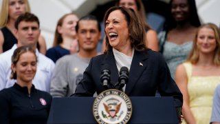 U.S. Vice President Kamala Harris laughs as she delivers remarks to the women’s and men’s NCAA championship teams in her first public appearance since President Joe Biden dropped out of the 2024 race, on the South Lawn of the White House in Washington, D.C., on July 22, 2024.