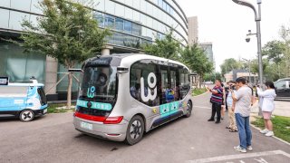 BEIJING, CHINA – JULY 11: People take photos of WeRide Robobus, a fully-driverless shuttle capable of SAE Level 4 autonomous driving, at Beijing High-level Autonomous Driving Demonstration Area on July 11, 2024 in Beijing, China. (Photo by Jia Tianyong/China News Service/VCG via Getty Images)