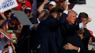 Republican presidential candidate, former U.S. President Donald Trump is whisked away by Secret Service after shots rang out at a campaign rally at Butler Farm Show Inc. on July 13, 2024 in Butler, Pennsylvania.