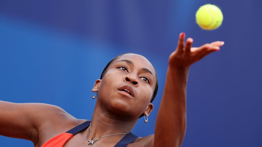 Tennis player Coco Gauff tosses a ball in the air