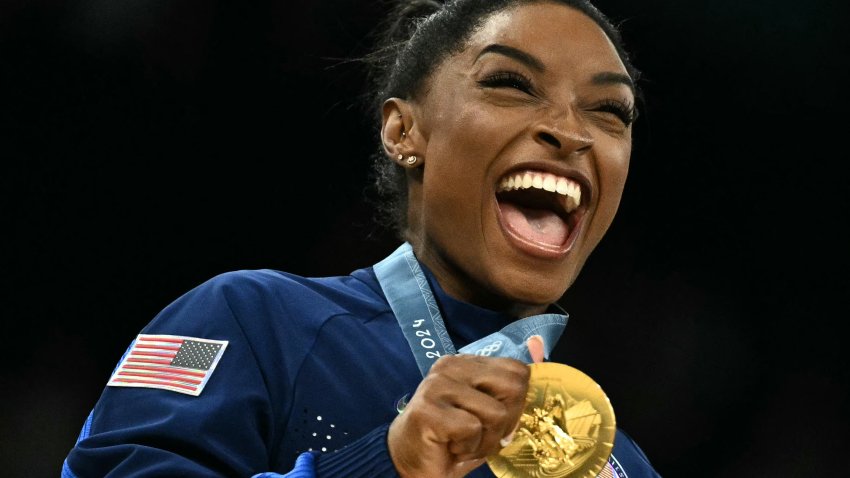 Simone Biles poses with the gold medal during the podium ceremony for the artistic gymnastics women's team final during the Paris 2024 Olympic Games at the Bercy Arena in Paris, on July 30, 2024.