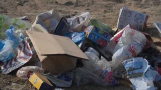 Piles of trash and food waste lie on San Diego's sandy beach, July 5, 2024.