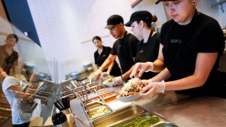 Employees prepare orders for customers at a Chipotle Mexican Grill restaurant in Hollywood, California.