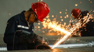 Workers process seamless steel pipes at a production line in Huai ‘an, Jiangsu province, China, Oct 20, 2022.