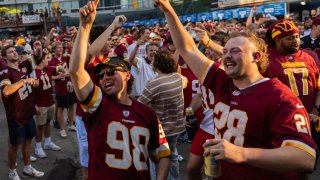 Washington Commanders fans celebrate after NFL team owners unanimously approved Josh Harris’ purchase of the team from Daniel Snyder, at The Bullpen’s “Burgundy and Sold” party on July 20, 2023.