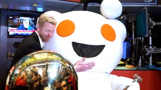 Reddit CEO Steve Huffman hugs mascot Snoo as Reddit begins trading on the New York Stock Exchange on March 21, 2024.