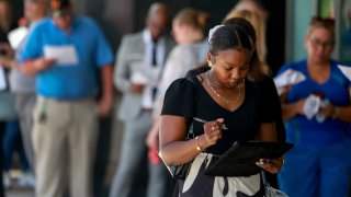 People line up as they wait for the JobNewsUSA.com South Florida Job Fair to open at the Amerant Bank Arena on June 26, 2024, in Sunrise, Florida. 