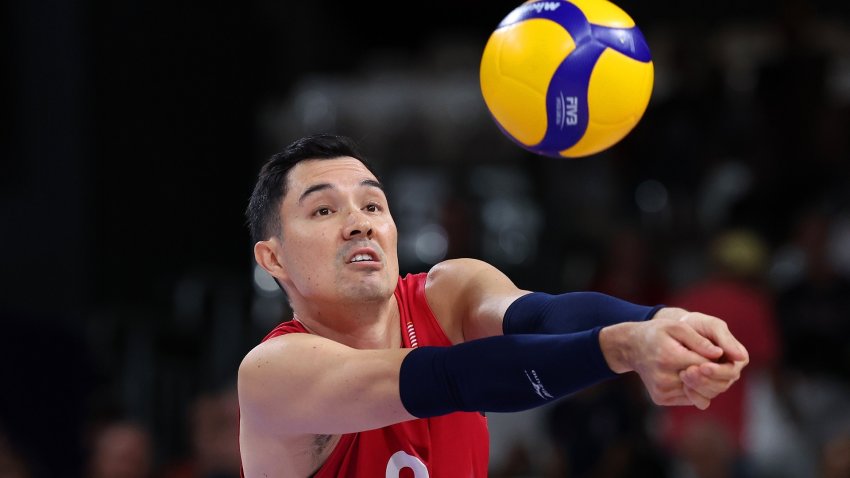 A volleyball player block hitting a ball.