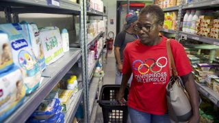 Jeanne Musaga shops at a social group store, Tuesday, Aug. 6, 2024, during the 2024 Summer Olympics, in Epinay-sur-Seine, France.