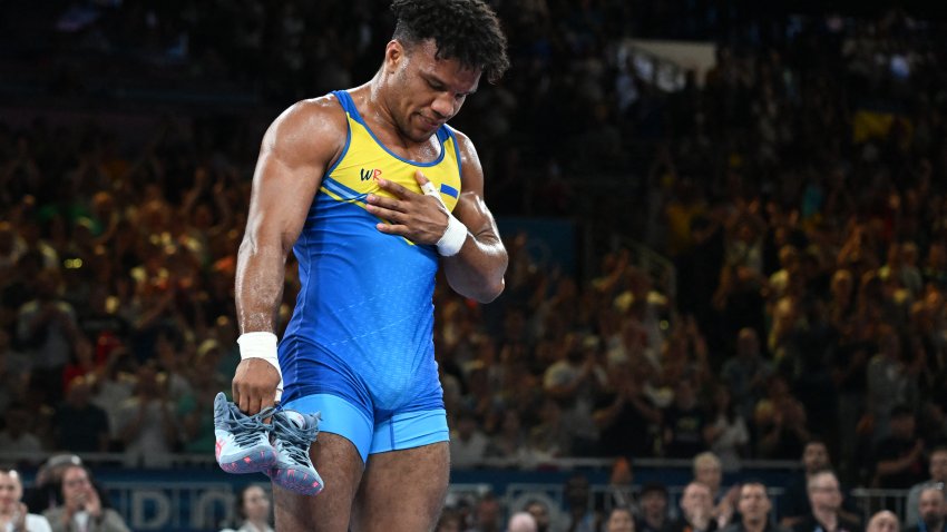 Ukraine's Zhan Beleniuk leaves his shoes in the ring as he retires after beating Poland's Arkadiusz Marcin Kulynycz in their men's greco-roman 87kg wrestling bronze medal match at the Champ-de-Mars Arena during the Paris 2024 Olympic Games, in Paris on August 8, 2024.