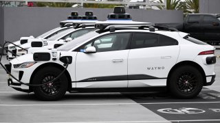 A Waymo autonomous self-driving Jaguar electric vehicle sits parked at an EVgo charging station in Los Angeles, California, on May 15, 2024.