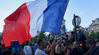 A French flag is seen on the Place de la Republique as people celebrate after the Nouveau Front Populaire, an alliance of left wing parties including the far-left wing party, La France Insoumise came in first on July 07, 2024 in Paris, France. 