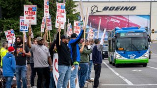 Workers with picket signs outside the Boeing Co. manufacturing facility during a strike in Everett, Washington, US, on Friday, Sept. 13, 2024. 