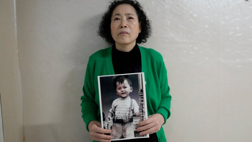 Choi Young-ja holds a photo of her son, who went missing in 1975, in her motel room in Seoul, South Korea, Tuesday, March 5, 2024.