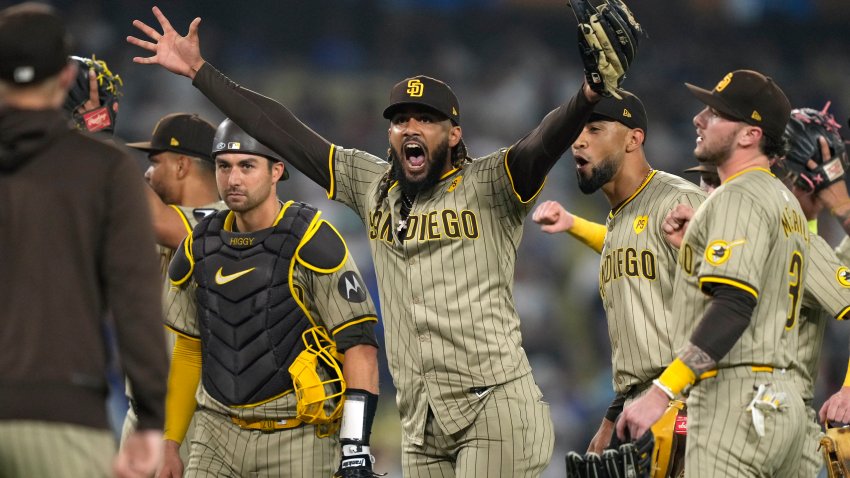 San Diego Padres’ Fernando Tatis Jr., center, celebrates with teammates after the Padres clinched a playoff spot with a triple play to end their baseball game against the Los Angeles Dodgers, Tuesday, Sept. 24, 2024, in Los Angeles. (AP Photo/Mark J. Terrill)