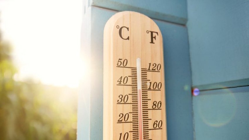 FILE. Thermometer on a blue wooden wall on a hot day.