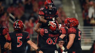 SAN DIEGO, CA – AUGUST 31: San Diego State running back Marquez Cooper (15) is lifted into the air by San Diego State offensive lineman Ross Ulugalu-Maseuli (63) after running for a touchdown during a college football game between the Texas A&M-Commerce Lions and the San Diego State Aztecs on August 31, 2024, at Snapdragon Stadium in San Diego, CA. (Photo by Chris Williams/Icon Sportswire via Getty Images)