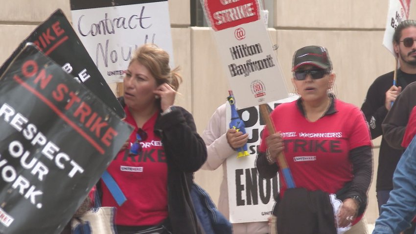 Union workers in red t-shirts with signs on a picket line