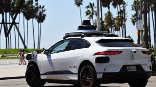 A Waymo autonomous self-driving Jaguar taxi drives along a street on March 14, 2024 in Los Angeles, California. 