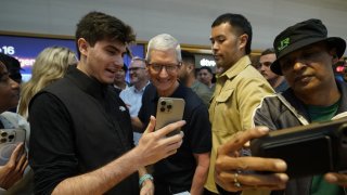 Apple CEO Tim Cook (C) joins customers during Apple’s iPhone 16 launch in New York on September 20, 2024.