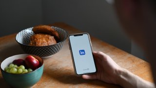 A man opens the LinkedIn social network app on his smartphone at the breakfast table in Berlin on July 5, 2024.