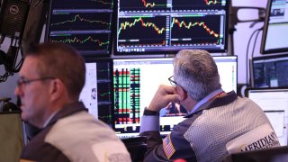 Traders work on the floor of the New York Stock Exchange during morning trading in New York City.ย
