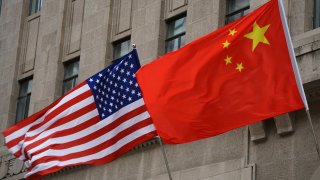 The national flags of the United States and China flutter at the Fairmont Peace Hotel on April 25, 2024 in Shanghai, China.