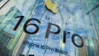 People walk past an advertisement for the iPhone 16 Pro at an Apple store during National Day holiday on October 3, 2024 in Chongqing, China.