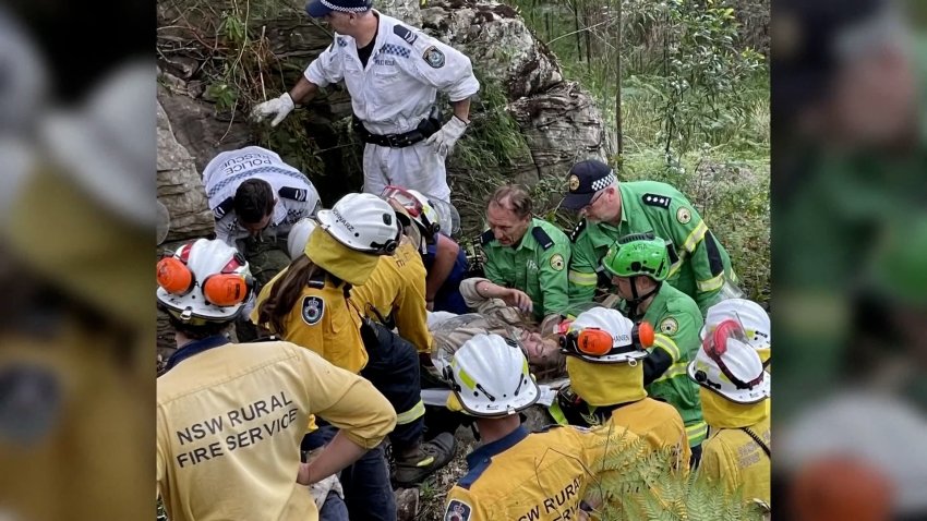 Rescue crews free a woman stuck between boulders.