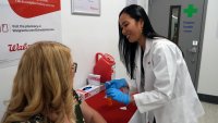 Anh Nguyen prepares to administer a COVID-19 vaccine for Kelly Vazquez at a pharmacy in New York, Tuesday, Sept. 24, 2024.