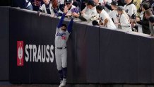 Fans interfere with a foul ball caught by Los Angeles Dodgers right fielder Mookie Betts during the first inning in Game 4 of the baseball World Series against the New York Yankees, Tuesday, Oct. 29, 2024, in New York. (AP Photo/Ashley Landis)