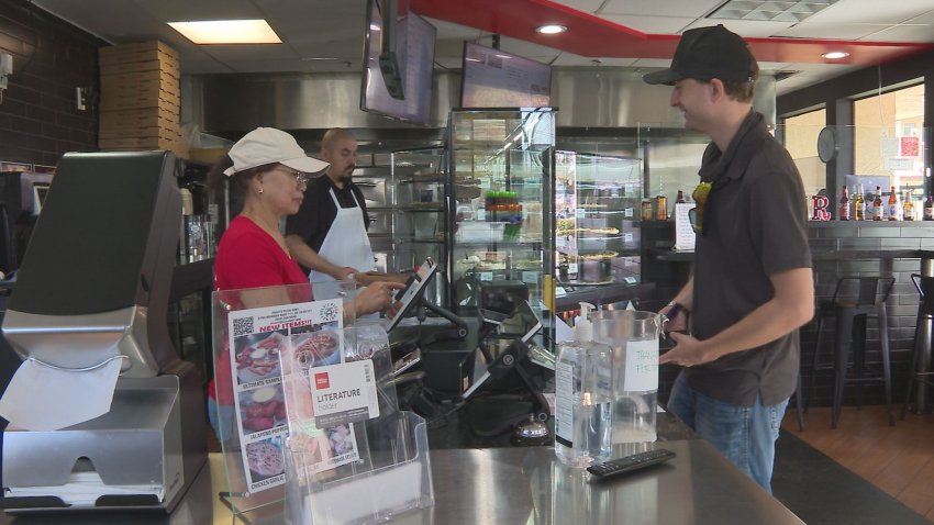 A man stands at a counter across from a woman.