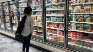 A customer shops in the ready to eat meals aisle of a grocery store on October 17, 2024 in Miami, Florida. 