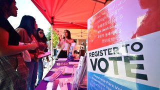 Potential young voters get information at a voter registration desk at Voter Fest 2024, an event designed to engage young voters and historically underserved communities on October 22, 2024 at Cal State Los Angeles in Los Angeles, California, ahead of the 2024 US presidential elections on November 5. 