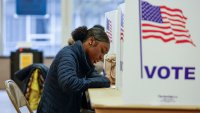 A woman casts her ballot during early voting for the US general election at a polling station at Ottawa Hills High School in Grand Rapids, Michigan, on November 3, 2024. 