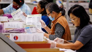CITY OF INDUSTRY, CA – NOVEMBER 5, 2024: Election workers inspect ballots after extracting them from envelopes on election night at the Los Angeles County Ballot Processing Center on November 5, 2024 in the City of Industry, California.