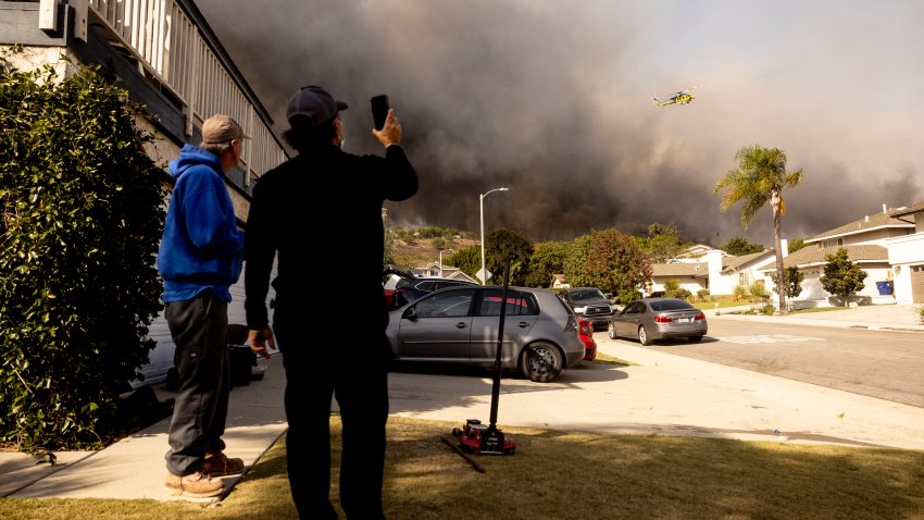 Residents watch a firefighting helicopter flying over the burning hills as the Santa Ana wind-fed Mountain fire scorches acres, in Camarillo, California, on November 6, 2024. A wildfire fanned by powerful winds was burning out of control near Los Angeles on November 6, with scores of residents ordered to evacuate and some taken to hospital.
Fierce gusts up to 80 miles (130 kilometers) an hour were pushing smoke sideways and fueling flames that were tearing through farmland. (Photo by ETIENNE LAURENT / AFP) (Photo by ETIENNE LAURENT/AFP via Getty Images)