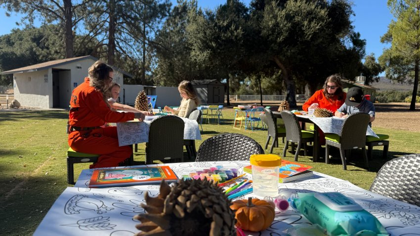 Nicole Packer, one of the inmates who trained as a firefighter at Puerta La Cruz Conservation Camp #14 in Warner Springs, bonds with her children at the camp's new education recreation center on Nov. 9. 2024. (NBC 7 San Diego)