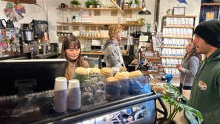 Maddy Holley (left) and Eddie Beal (right) are behind the counter serving customers at OB Beans Coffee Roasters, Saturday.